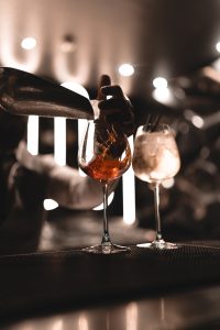 Bartender serving drinks at the modern bar counter of Aura Grill and Bar